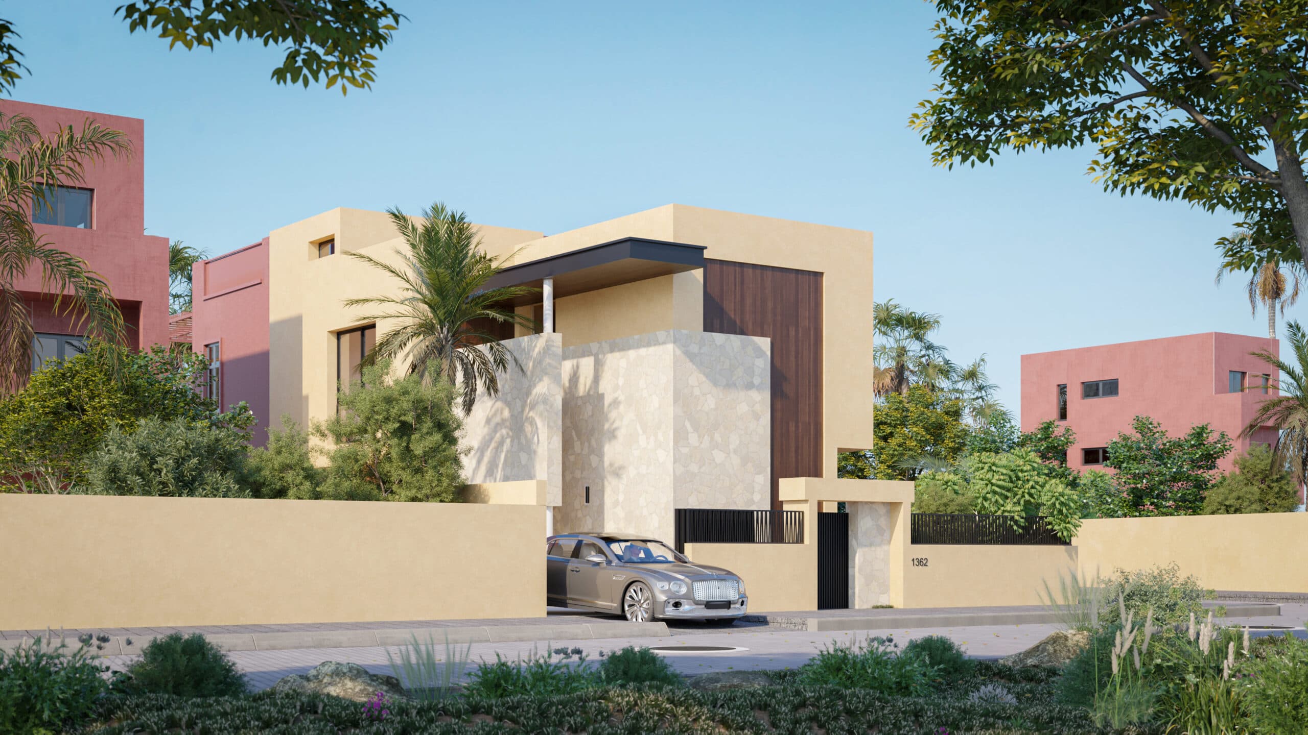 Une maison beige moderne avec des accents de pierre et de grandes fenêtres est entourée d'une végétation luxuriante et d'un mur jaune. Une voiture de luxe argentée est garée dans l'allée. D'autres maisons colorées sont visibles à l'arrière-plan sous un ciel clair.