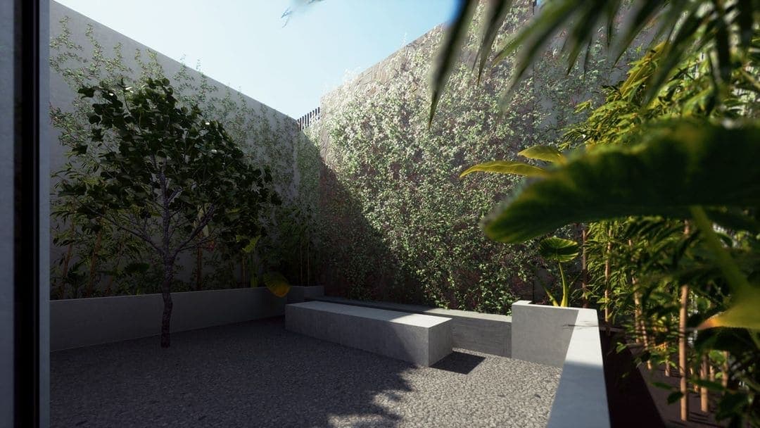 Une petite cour moderne conçue par un architecte de Marrakech comprend des bancs en béton, un sol en gravier, des plantes vertes à feuilles et un arbre, le tout entouré de hauts murs drapés d'une verdure dense sous un ciel clair.