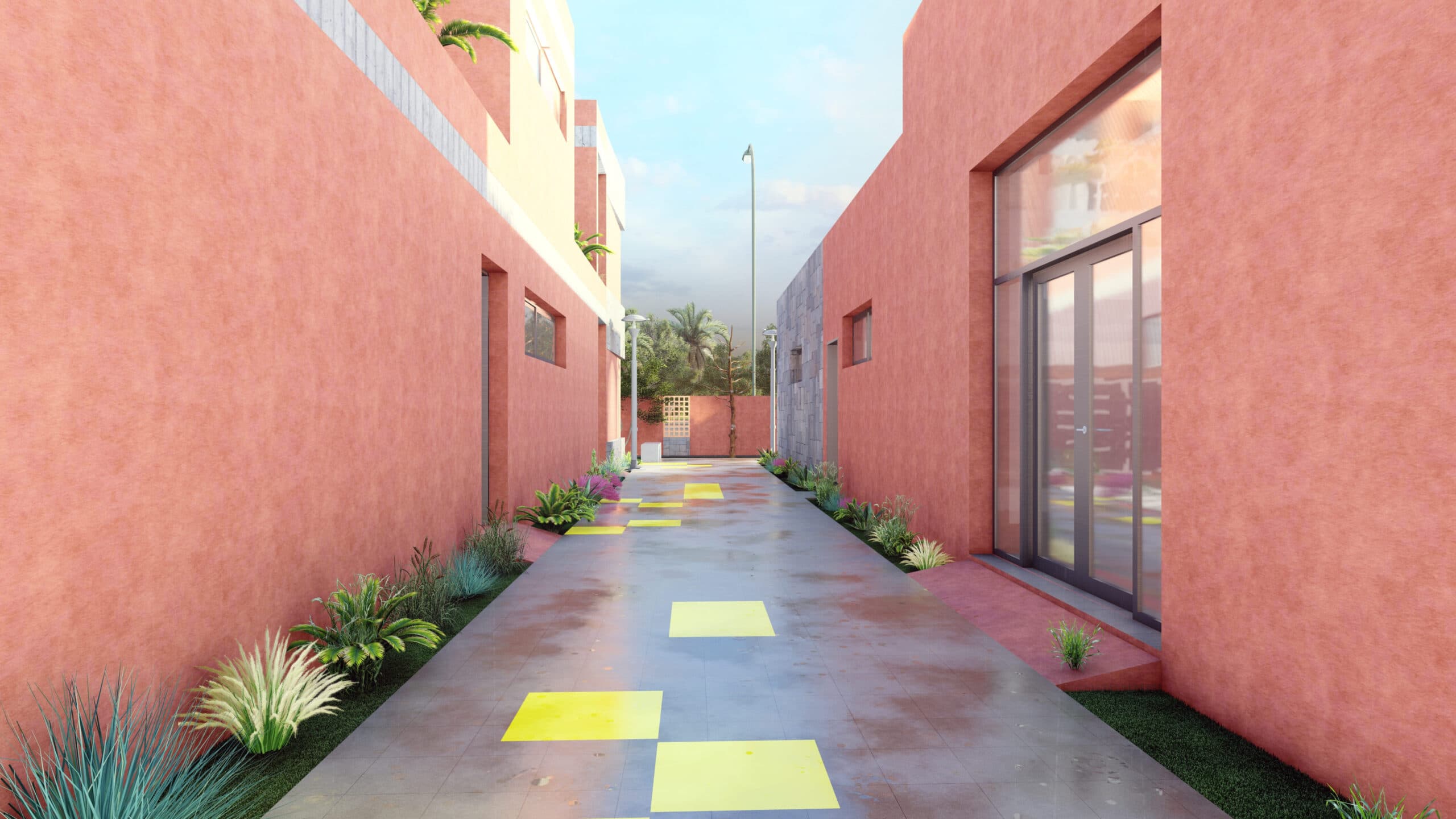 Une ruelle étroite avec des bâtiments rose-rouge de part et d'autre, bordée de petites plantes. L'allée est carrelée de jaune et mène à un portail avec des palmiers visibles au loin sous un ciel partiellement nuageux.