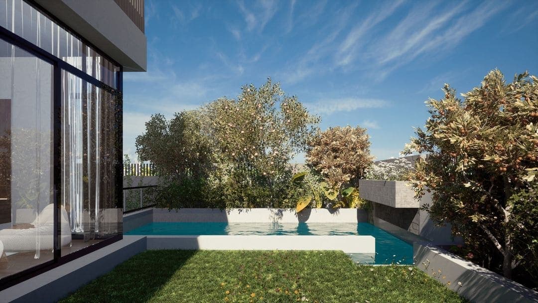 Un bâtiment moderne construit par un architecte de Marrakech présente de grandes baies vitrées, donnant sur une piscine rectangulaire entourée d'herbe verte et d'arbres, le tout sous un ciel bleu avec des nuages ondulants.